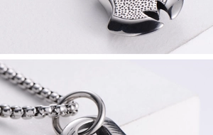 Macro shot of stainless steel evil eye pendant with square link chain and textured details