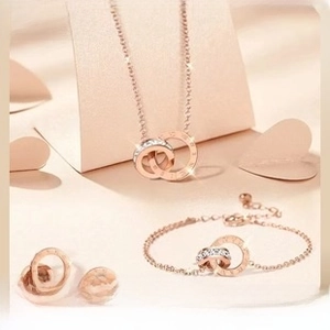 Macro detail of rose gold jewelry set featuring interlocking rings with Roman numerals