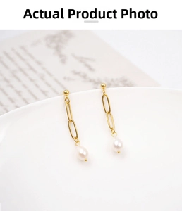 Detailed macro view of vintage pearl drop earrings on a white ceramic vessel