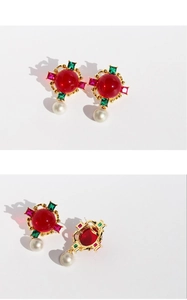 Macro shot of vintage style earrings with emerald green accents and elegant pearl details