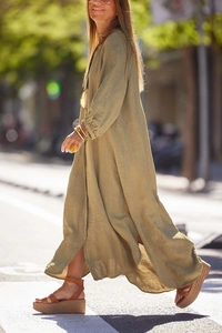 Dynamic street view of olive green linen long-sleeve maxi dress with side slit detail