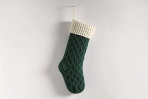 Makro-Detail von dunkelgrünem Strick-Weihnachtsstrumpf mit Rautenmuster-Struktur