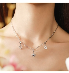 Close-up of S925 silver necklace with micro-pave heart, star, and eye charms on model