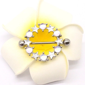 Close-up of silver nipple ring with star and pearl pendant on a frangipani flower