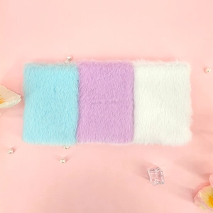 Detailopname van zachte pluche A7 mini-notitieboekjes in blauw, paars en wit snoepkleuren