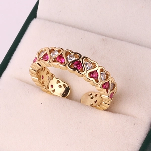Detail of adjustable golden ring with red and white zircon hearts in a jewelry box