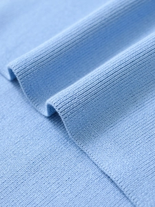 Close-up of light blue knit fabric showing soft texture and fine stitching detail