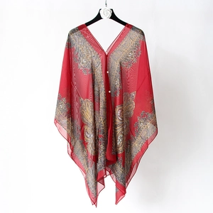 Detailed macro shot of elegant red paisley silk shawl with luxury pearl button accents
