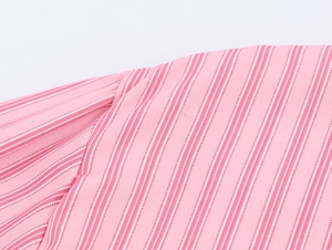 Dettaglio del tessuto di cotone a righe rosa con cuciture rifinite e trama tessuta