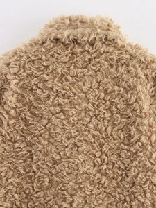 Gros plan d'une veste en polaire camel montrant la texture bouclée et les détails du tissu