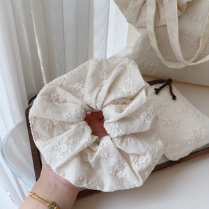 Close-up of cream cotton hair scrunchie with intricate floral embroidery details