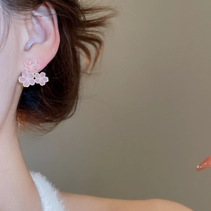 Détail de boucles d'oreilles fleur de cerisier en résine rose portées par un mannequin