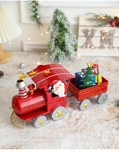 Détail d'un petit train de Noël rouge en fer avec Père Noël, sapin et boîtes cadeaux