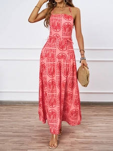 Detail of pink halter neck maxi dress with red palm prints and tied waist belt