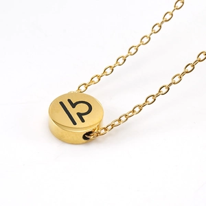 Macro detail of polished gold Libra zodiac sign pendant on a delicate O-chain necklace