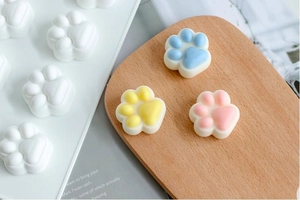 Detailed view of white silicone cat paw molds with colorful finished resin crafts