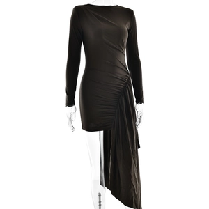 Detail of elegant black long sleeve dress featuring ruched design and asymmetrical draped fabric