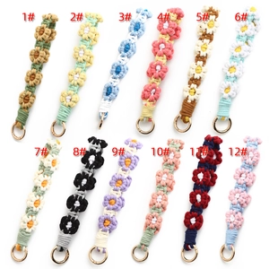 Handmade crochet daisy keychain charms in various colors with golden metal rings