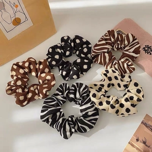 Vue détaillée du lot de 5 chouchous avec motifs à pois et zèbre en tissu texturé