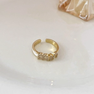 Macro dell'anello MIU placcato oro con micro-cristalli e dettagli in smalto bianco fine