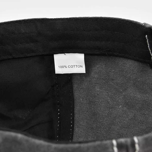 Macro detail of the 100% cotton inner label and washed fabric texture of the baseball cap