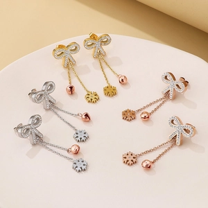 Elegant bow tassel earrings with snowflake charms in gold silver and rose gold