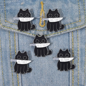 Cartoon black cat enamel pin set with knife design and pronoun badges on denim jacket