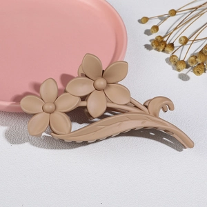 Detailed view of matte finish double flower hair claw clip on elegant textured surface