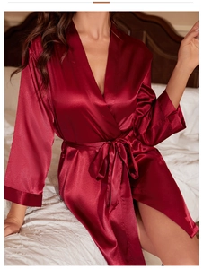 Détail de la texture satinée bordeaux et de la ceinture du peignoir en chambre