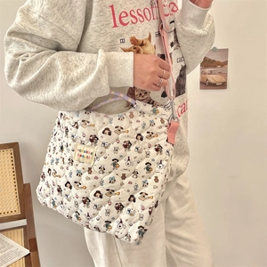 Detailed shot of quilted canvas crossbody bag with cartoon dog prints and pink strap