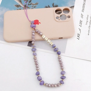 Purple crystal stone phone charm with LOVE letter beads on a pink phone case background