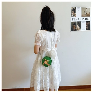 Dettaglio di una borsa a tracolla verde a forma di stella con accenti dorati e catena