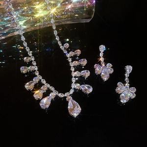 Detail of silver tassel necklace and flower earrings with pear shaped cubic zirconia