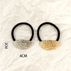 Close-up of gold and silver hammered oval hair ties measuring 2cm by 4cm on white background