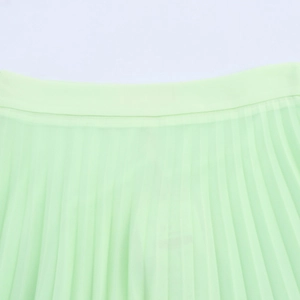 Close-up of the pleated waistband and texture on a light green flowy maxi skirt