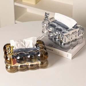 Detailed close-up of amber and clear tissue boxes with metallic bear accents