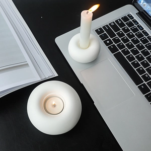 Minimalist white ceramic round candle holders in a cozy lifestyle desk setting