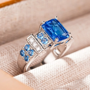 Macro side view of a rectangle blue gemstone ring with detailed prong setting craftsmanship