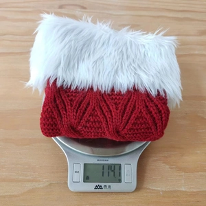 Detailed view of the red knitted Christmas stocking on a scale weighing 114.1 grams
