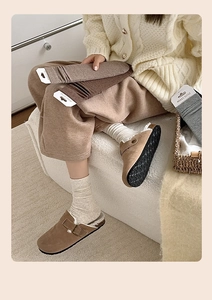 Detail of soft winter crew socks in earthy tones paired with plush buckled clogs