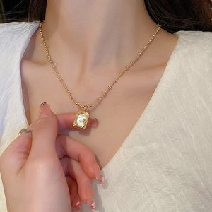 Minimalistische goldene Halskette mit weißem Muschelanhänger am Model getragen