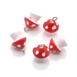 Close-up of red and white spotted mushroom charms with silver rings for DIY jewelry making