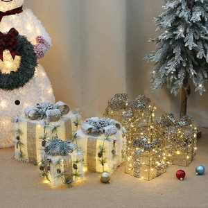 Close-up of LED Christmas gift box set with burlap bows and pine cone decorations