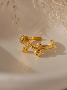 Macro detail of elegant gold PVD bow ring showing polished texture and open band design