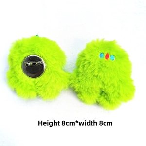 Detail showing the front and back of a plush 8x8cm neon green monster brooch with pin