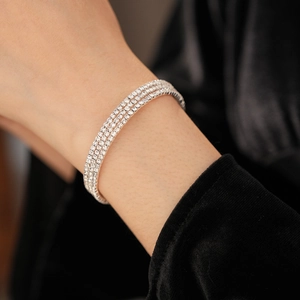 Macro shot of silver triple-row tennis bracelet with sparkling pave-set zircons on wrist