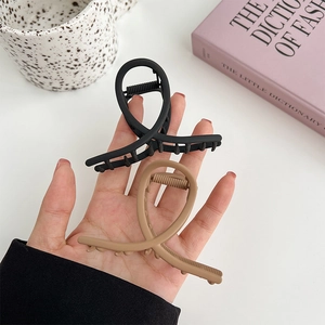 Matte finish cross hair clips in black and khaki shown in hand for daily styling