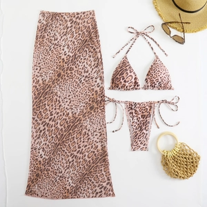 Flat lay of leopard print mesh skirt with bikini and beach holiday accessories