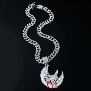 Macro shot of silver Cuban link necklace with iced-out crescent moon dripping blood pendant