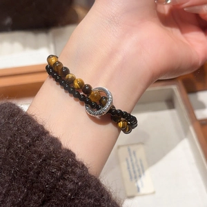 Detailed close-up of a double-layer bracelet with tiger eye stones and black beads
